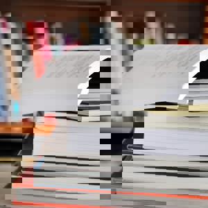 Pile of textbooks with top book open